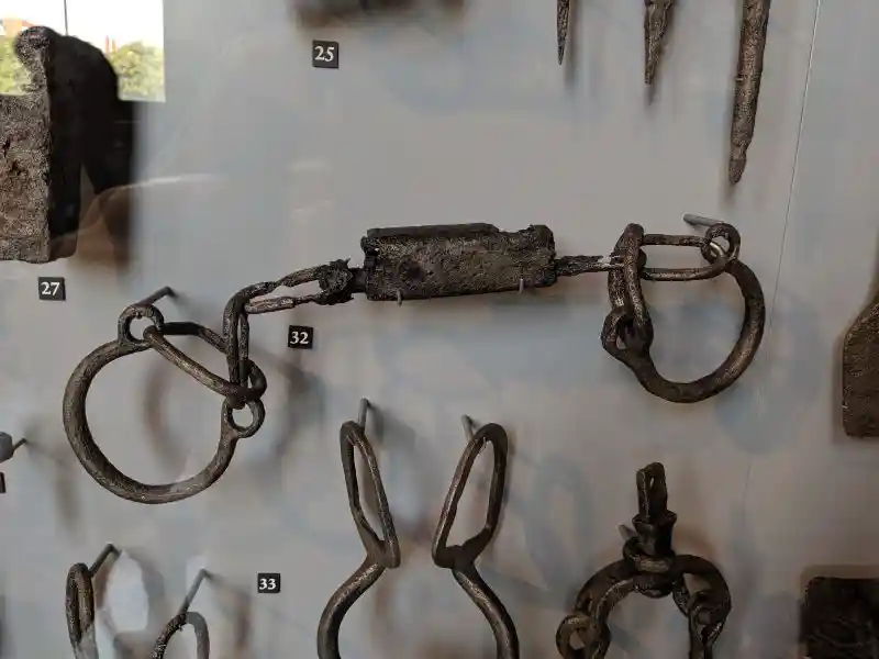 Iron legcuffs (Doppelfessel) from the early medieval period, displayed with other iron tools